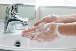 Rennende vann og hender som blir vasker med såpe.