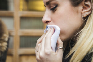 Ung kvinne tørker munne med en serviett.